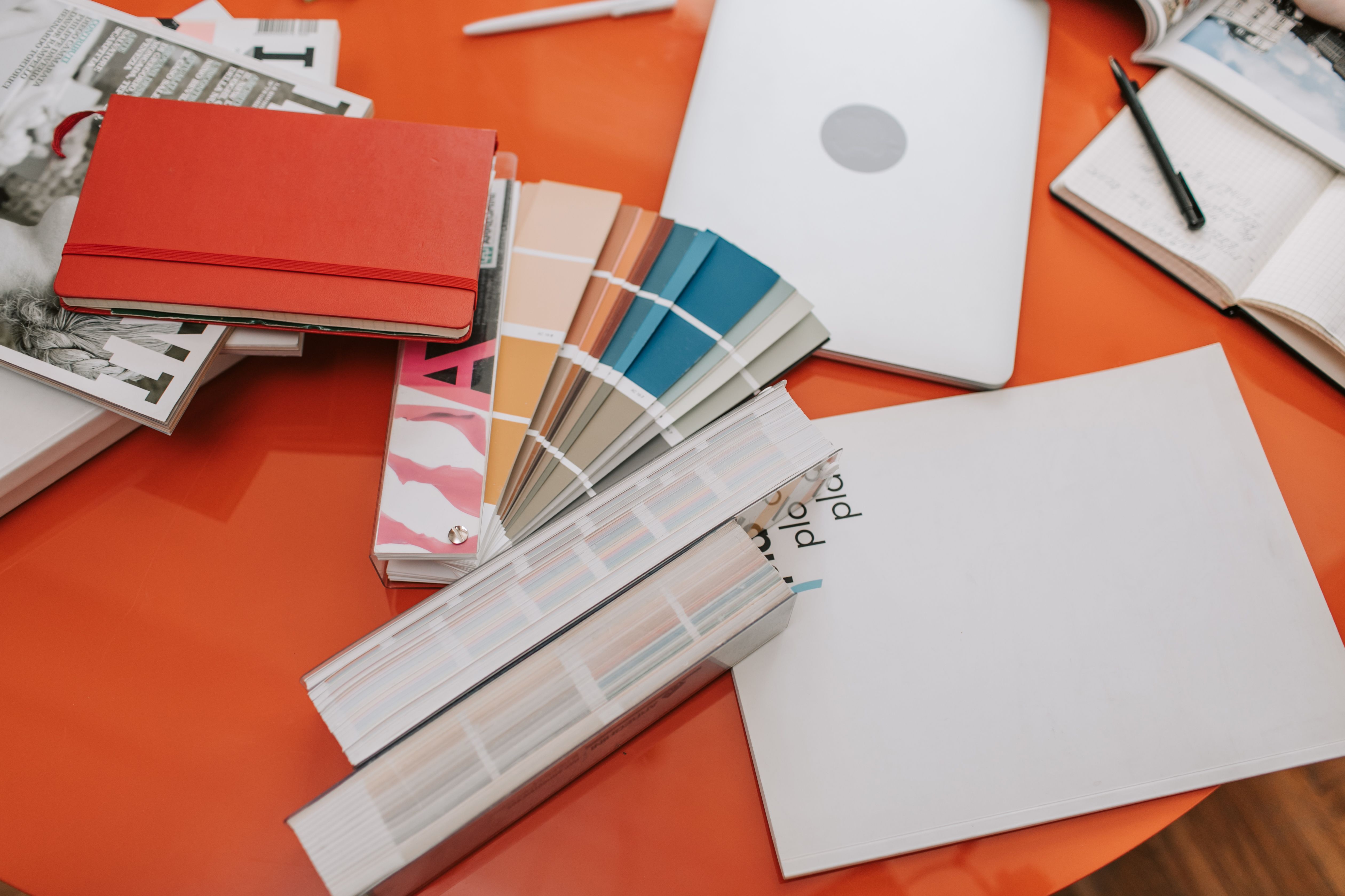Design workspace with color swatches, books, and laptop, illustrating visual branding development.